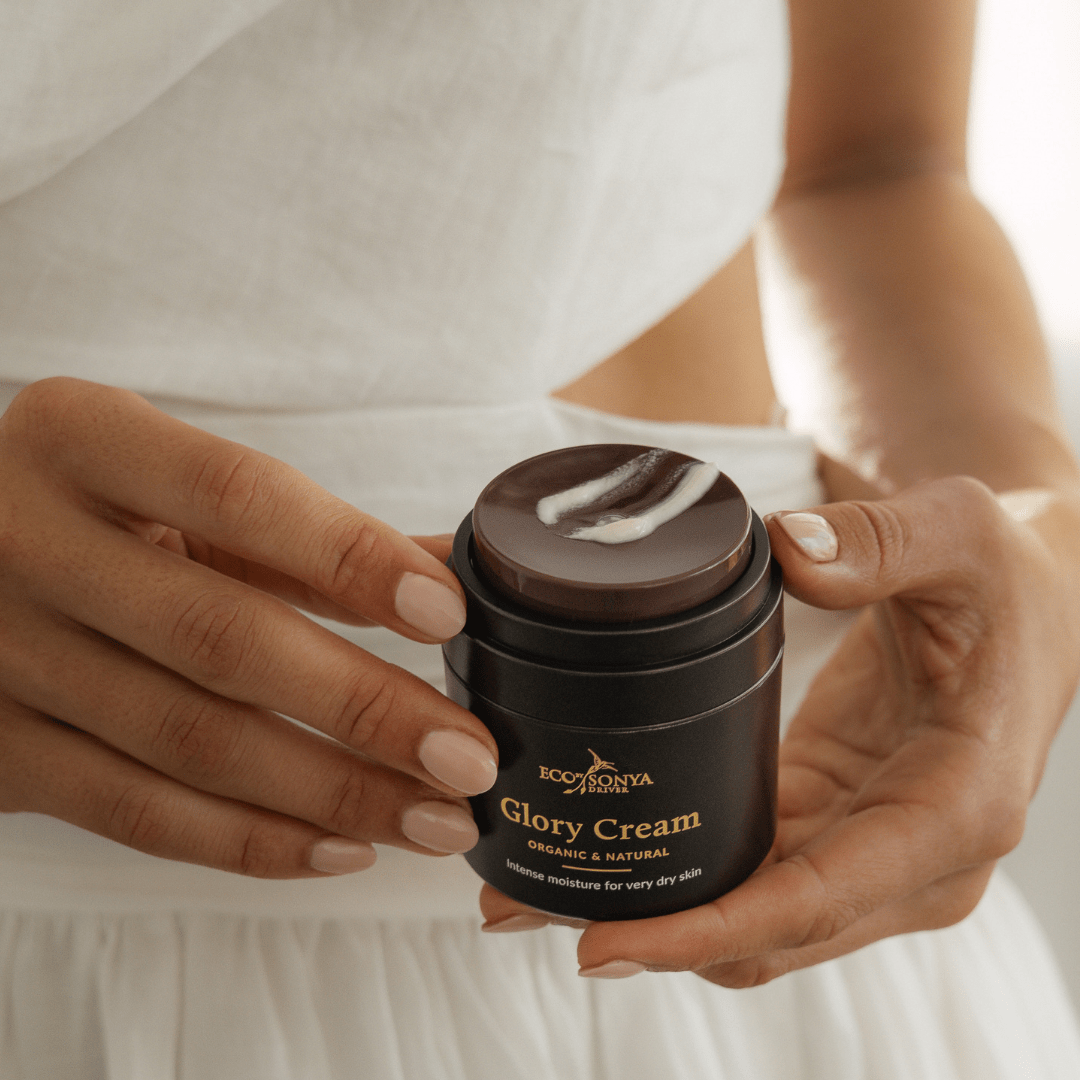 Person holding a jar of natural Glory Cream with a white background with cream smear - Eco By Sonya UK